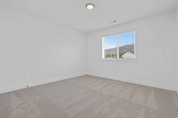 Spare room featuring baseboards and light colored carpet