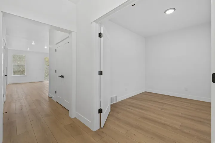 Hallway with light wood finished floors and recessed lighting