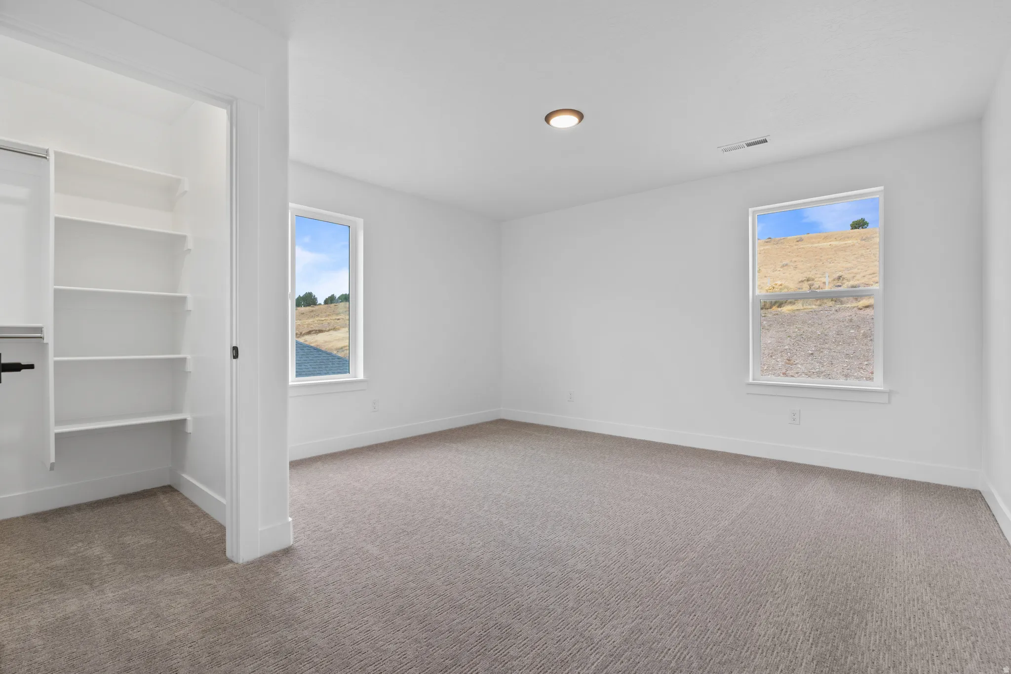 Unfurnished room featuring light colored carpet and baseboards