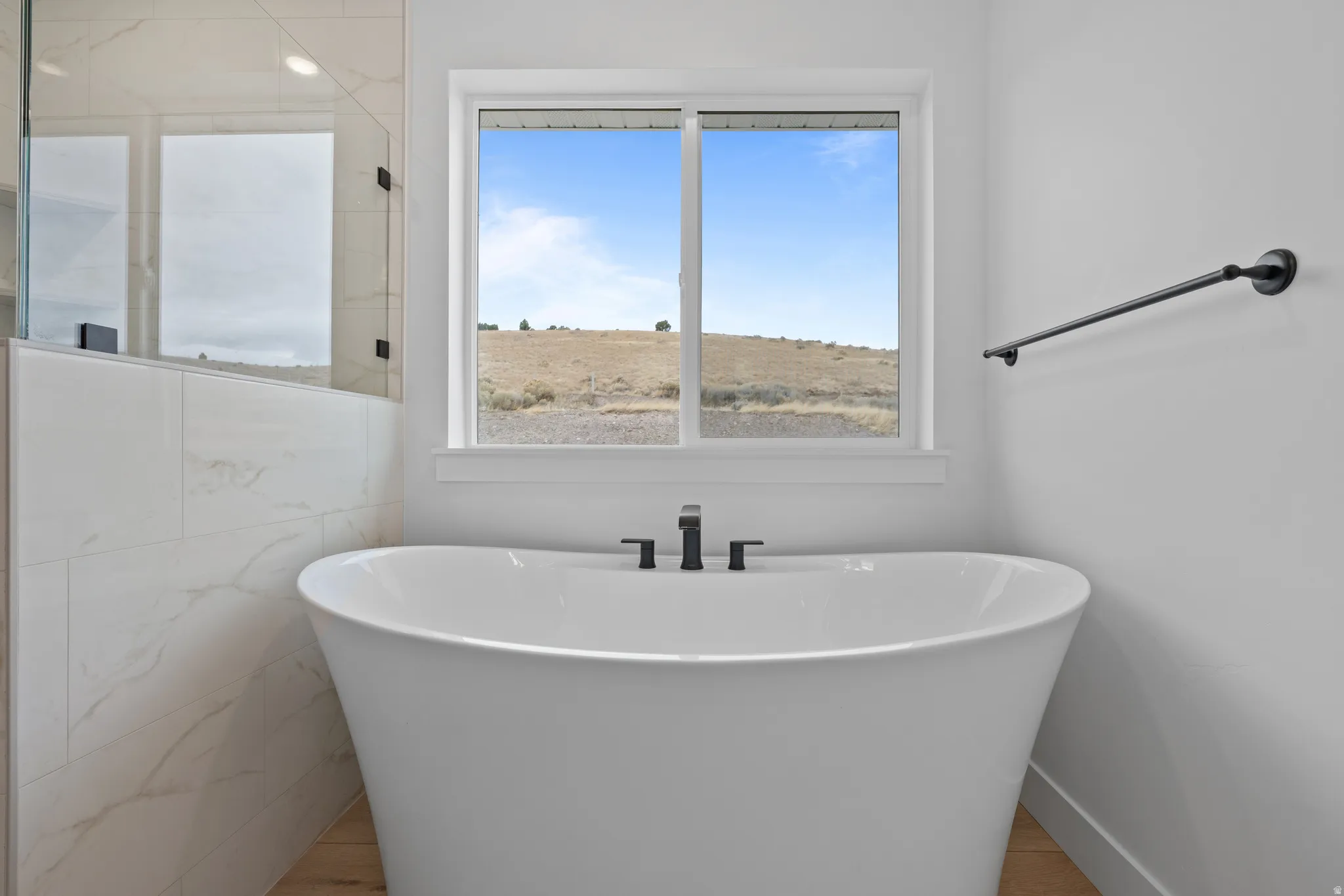 Bathroom featuring a freestanding tub and wood finished floors