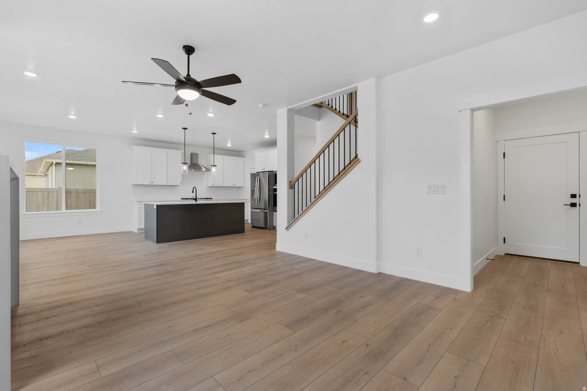 Unfurnished living room with ceiling fan, light wood-type flooring, and recessed lighting