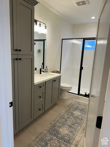 Bathroom featuring vanity, a stall shower, and recessed lighting