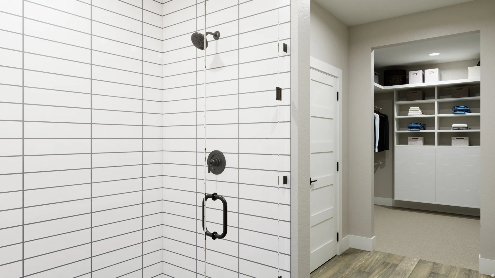 Bathroom featuring a stall shower, wood finished floors, and a walk in closet
