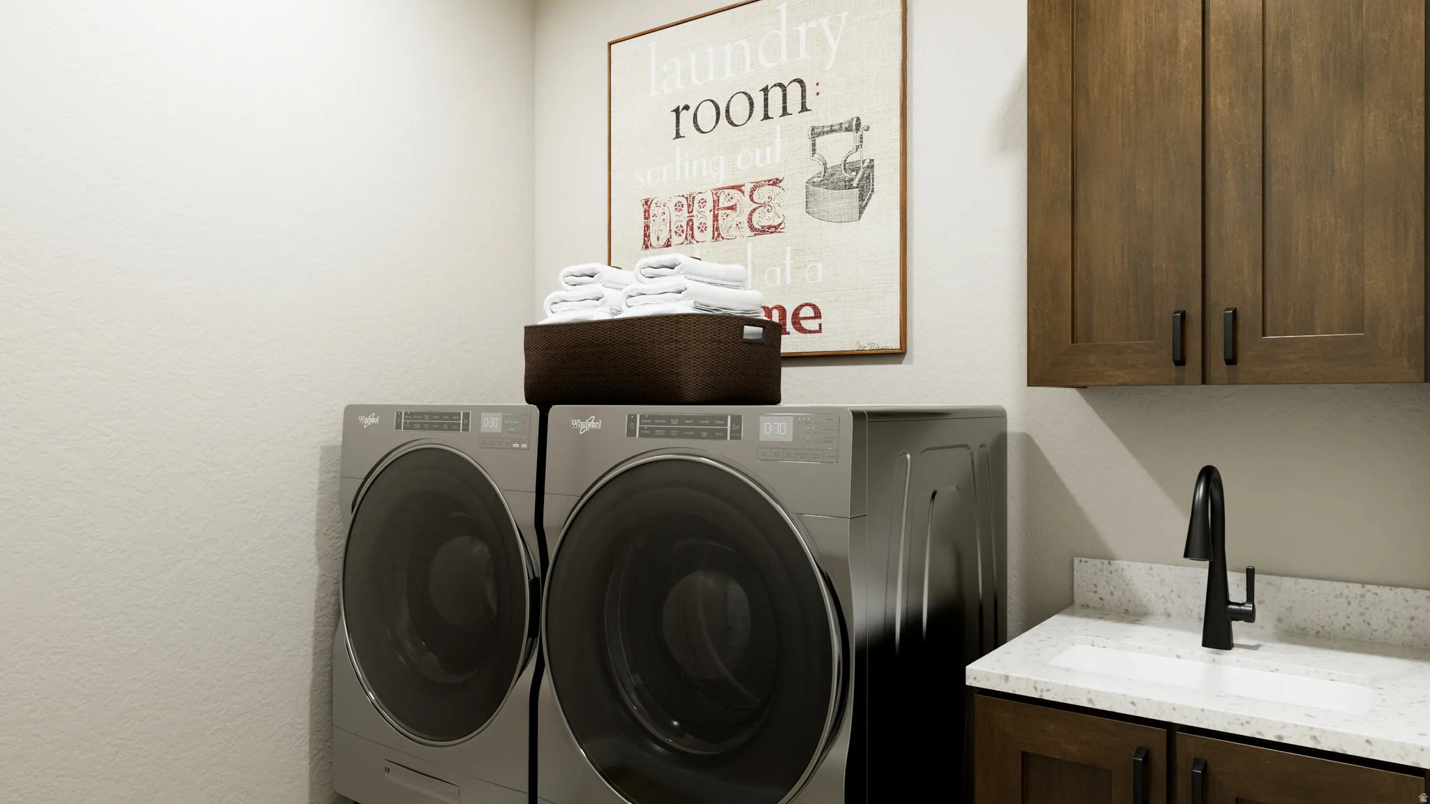 Laundry room with separate washer and dryer, a textured wall, and cabinet space