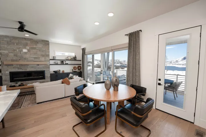 Dining space with a fireplace, ceiling fan, light wood-type flooring, and recessed lighting