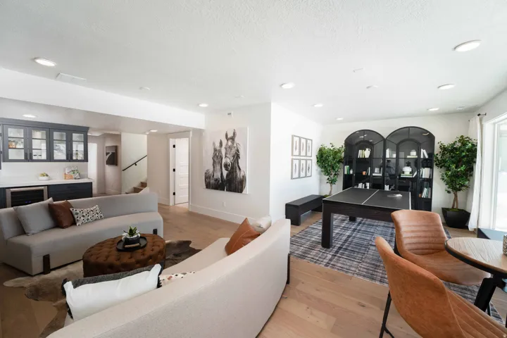 Living room featuring light wood-type flooring, wine cooler, recessed lighting, a textured ceiling, and a bar