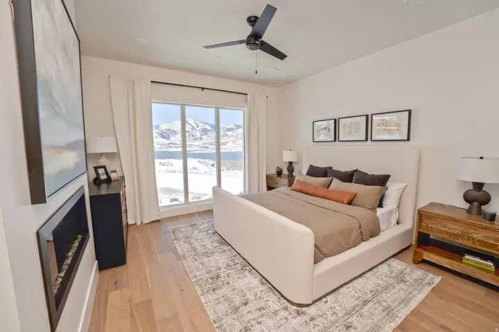 Bedroom featuring light wood finished floors, a mountain view, and ceiling fan