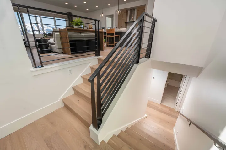Staircase with wood finished floors and recessed lighting