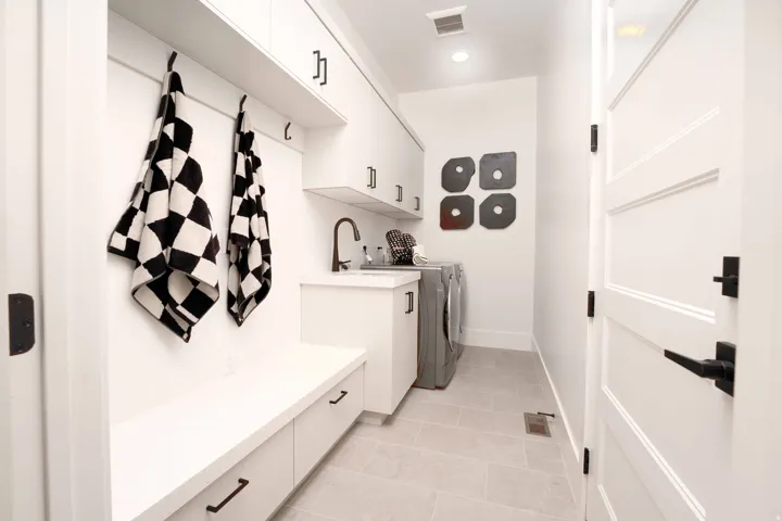 Laundry room featuring washing machine and clothes dryer, cabinet space, light tile patterned floors, and recessed lighting