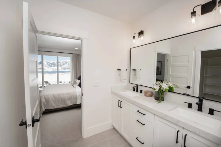 Ensuite bathroom with double vanity, light tile patterned flooring, light carpet, and a mountain view