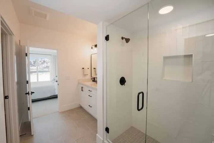 Ensuite bathroom featuring vanity, a stall shower, and light tile patterned floors