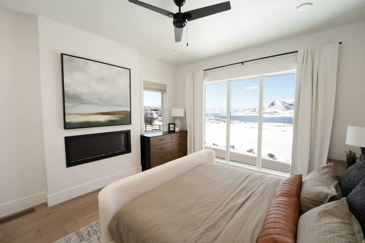 Bedroom with access to exterior, light wood-type flooring, a mountain view, and ceiling fan