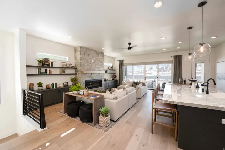 Living area featuring light wood finished floors, plenty of natural light, a fireplace, ceiling fan, and recessed lighting