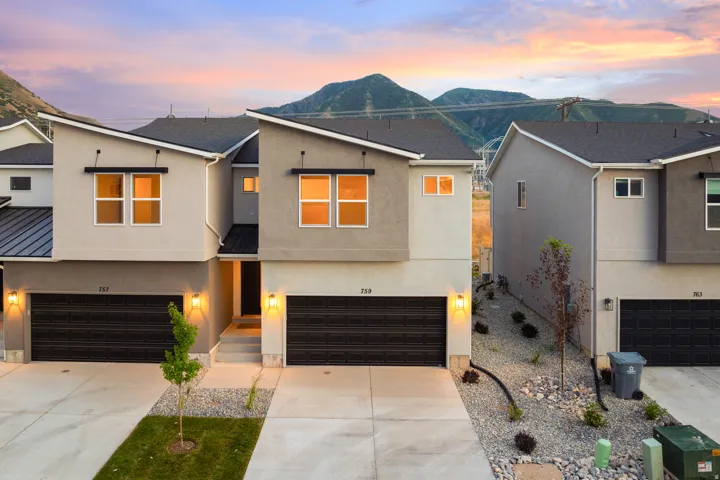 View of front of property with stucco siding, a garage, concrete driveway, and a mountain view