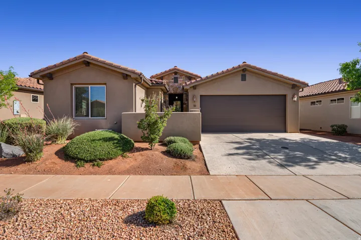Mediterranean / spanish home featuring driveway, stucco siding, a garage, and a tile roof