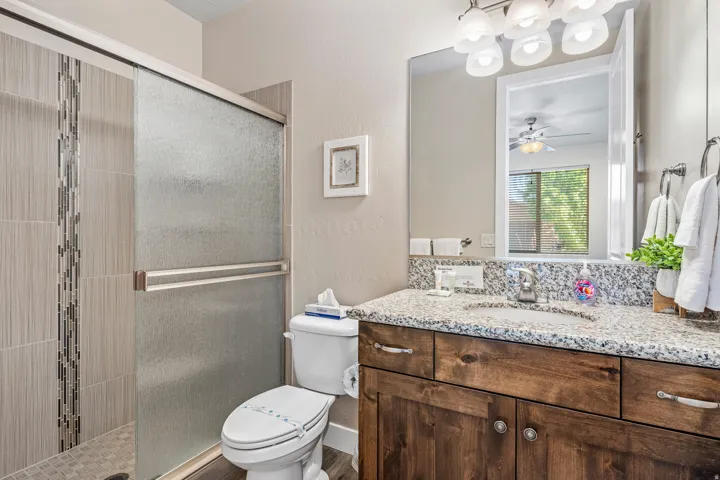 Casita Full bathroom featuring a shower stall, a textured wall, vanity, and ceiling fan