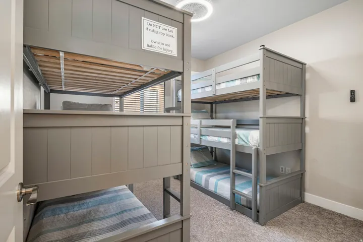 Bunk room featuring light carpet and baseboards