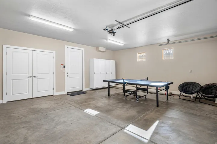 Game room featuring concrete flooring, a garage, and a textured ceiling