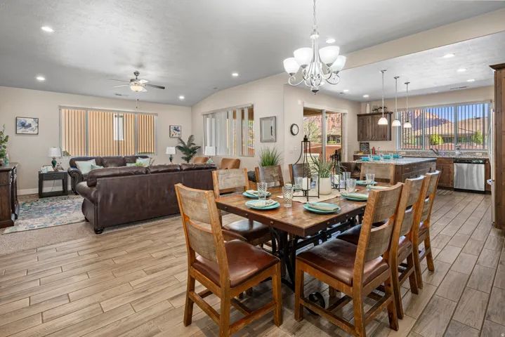 Dining room featuring ceiling fan, wood tiled floors, plenty of natural light, and suspended lighting