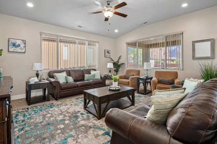 Living room featuring a ceiling fan, recessed lighting, plenty of natural light, vaulted ceiling, and carpet