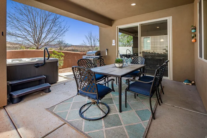 View of patio / terrace with outdoor dining space, a hot tub, and a grill