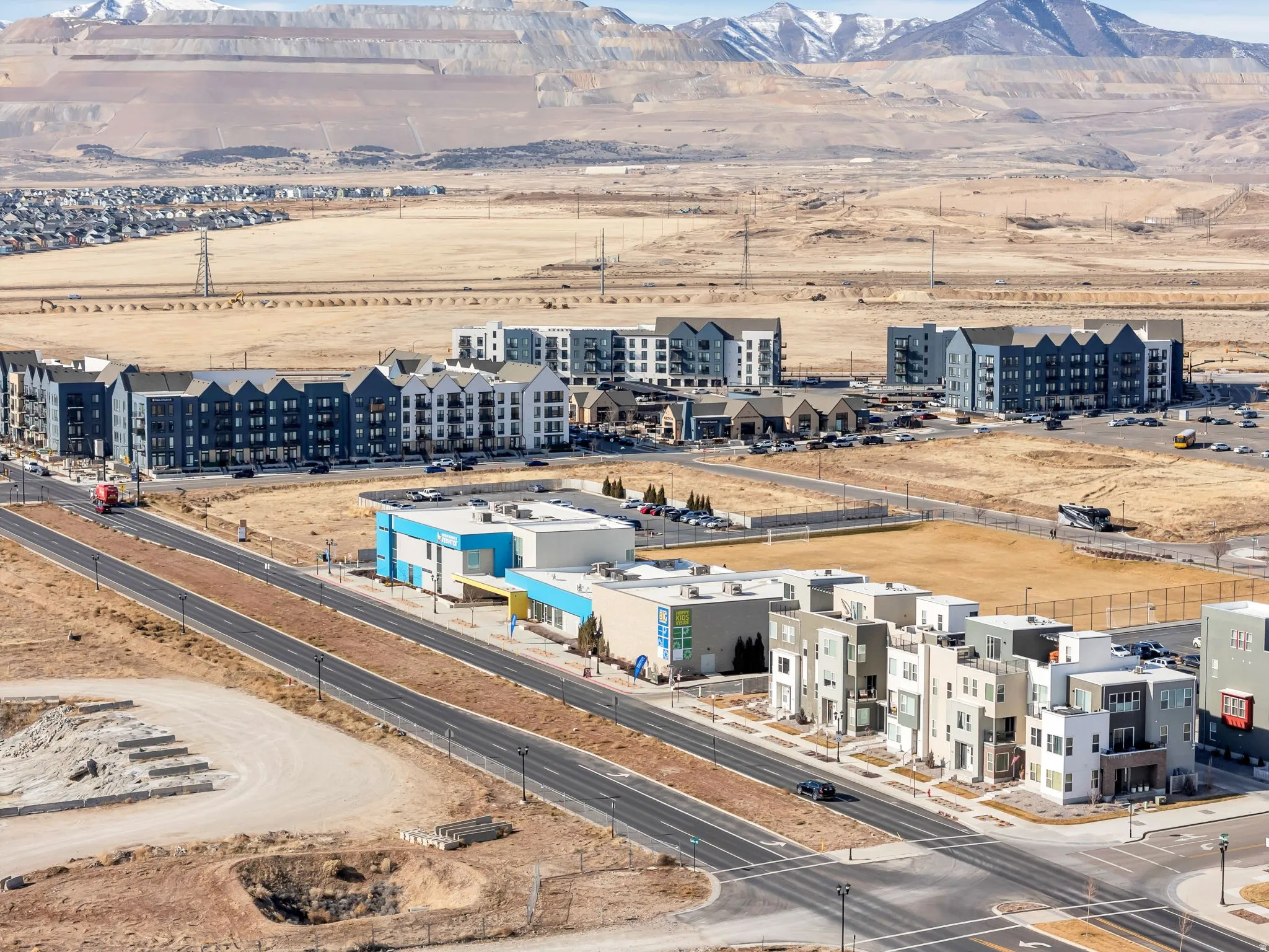 Drone / aerial view of a mountain backdrop and apartment complex / building