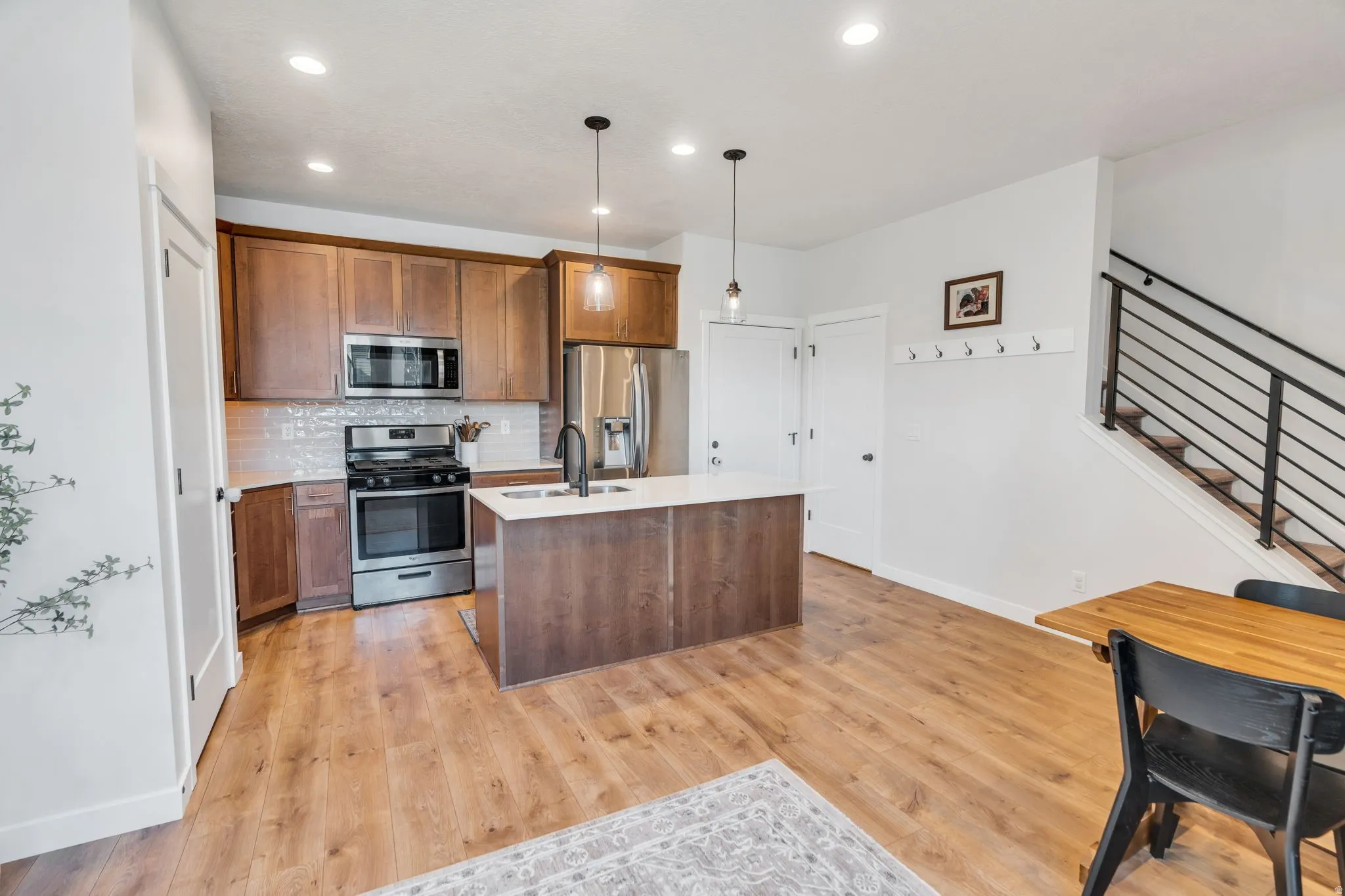 Beautiful kitchen featuring garage door entrance, wall hooks featuring the upper level staircase