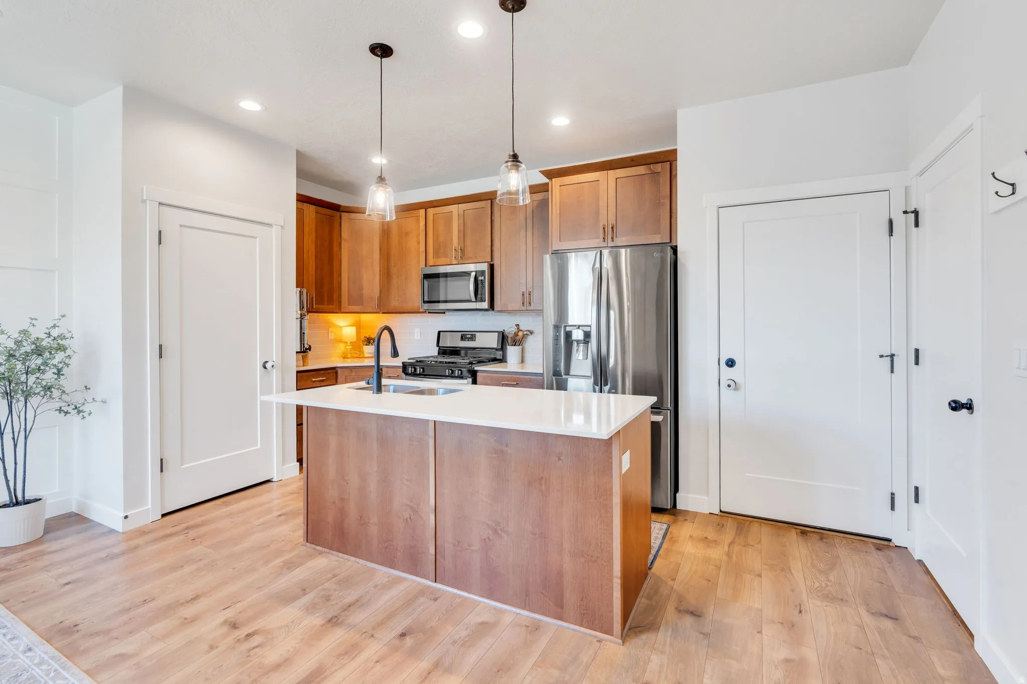 Beautiful kitchen featuring recessed and overhead lighting, rich kitchen cabinets and garage door entry