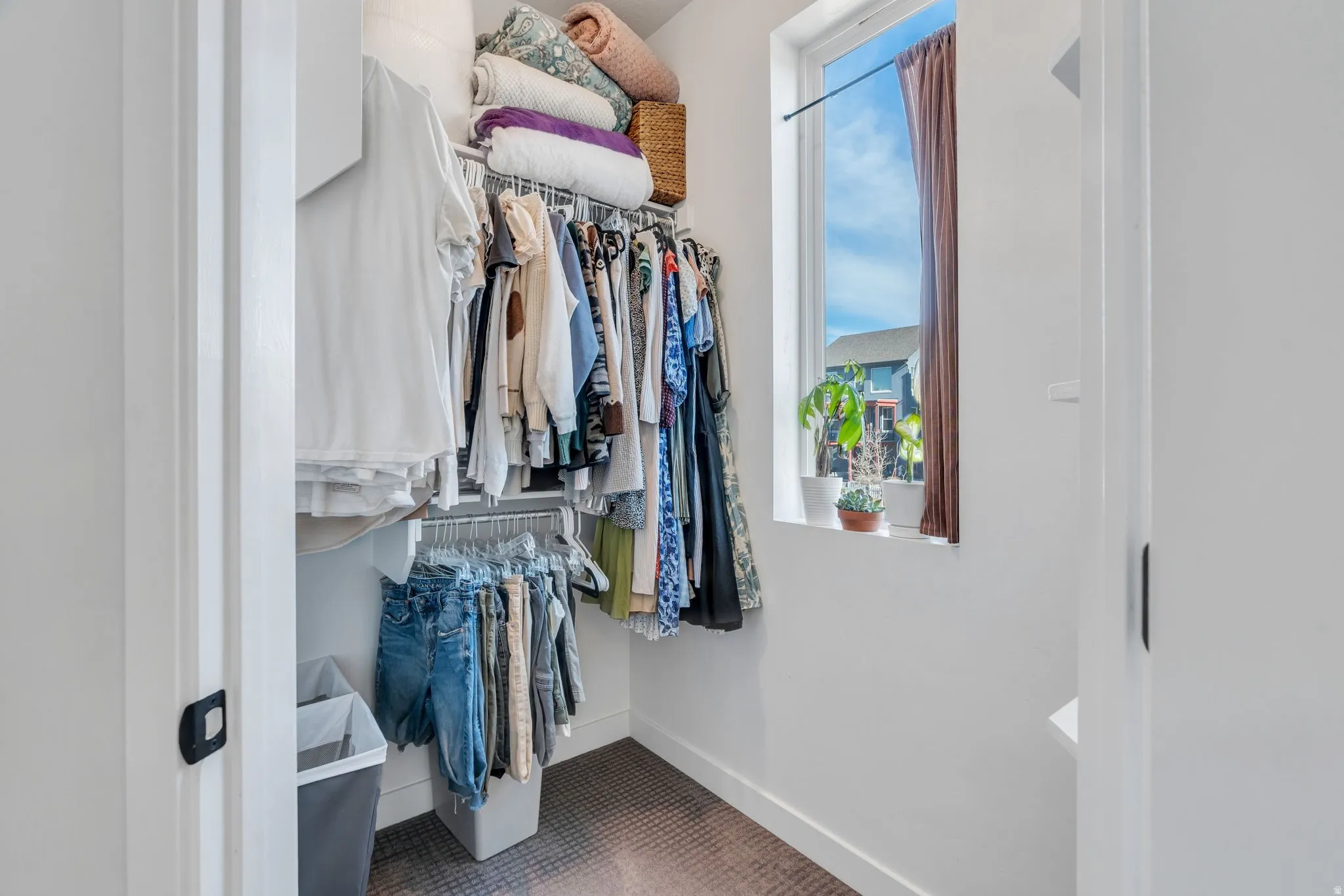 Spacious walk-in closet with built in hanging racks, featuring natural light