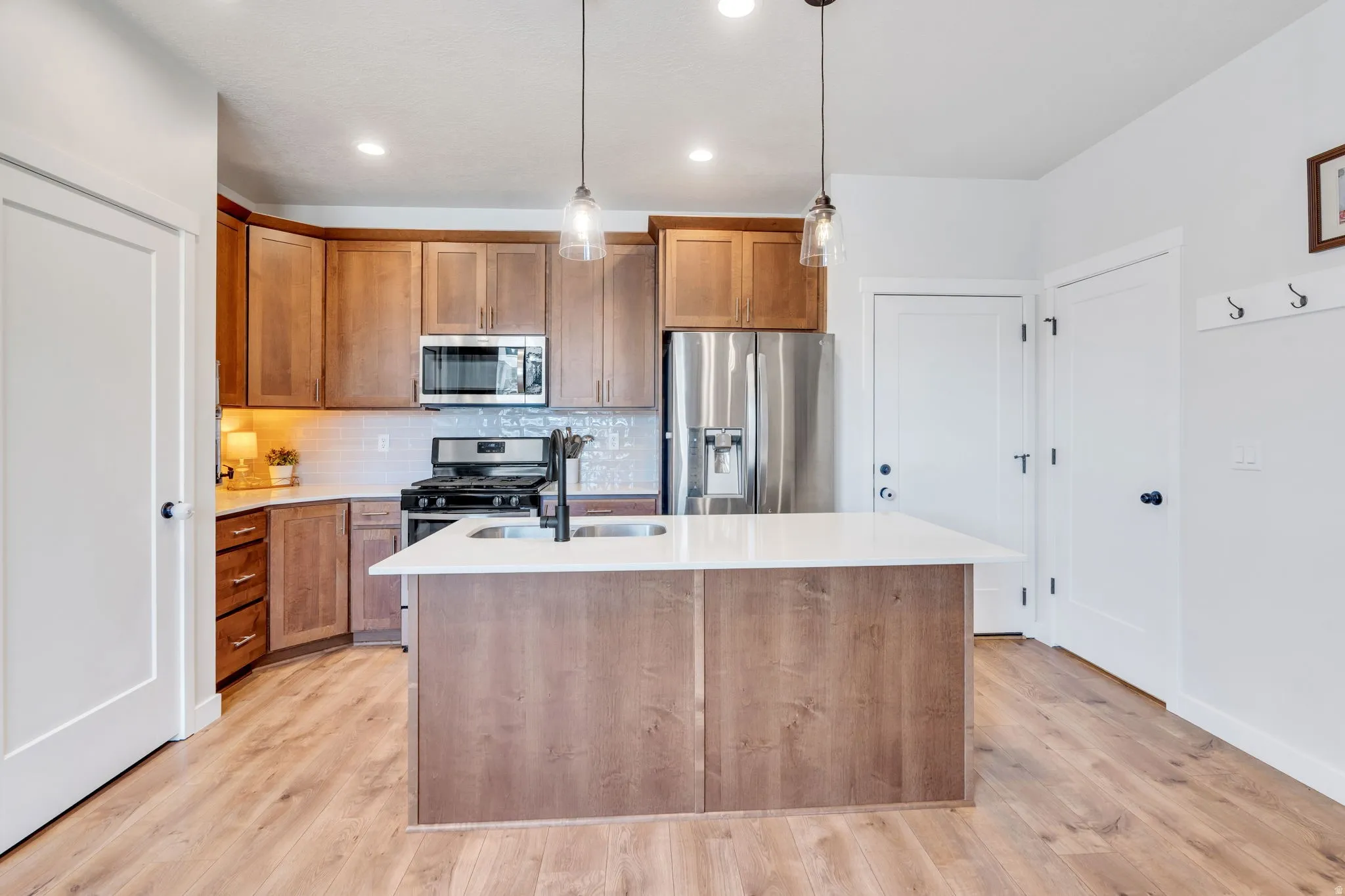 Featuring wood like flooring, plentiful cabinet space, and stainless-steel appliances