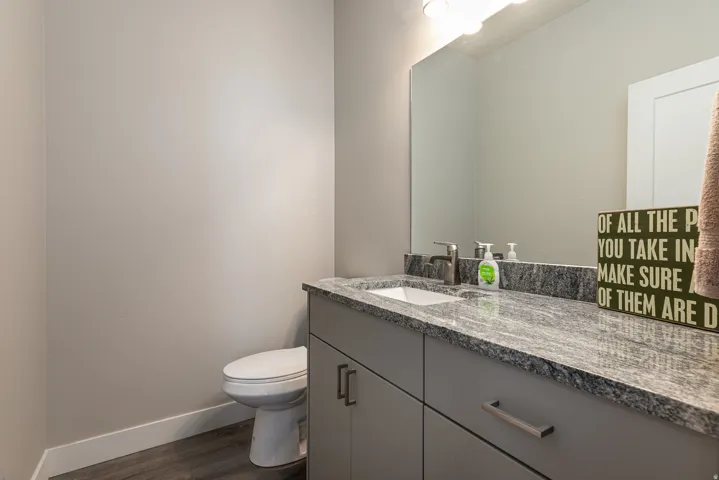 Half bath with vanity and dark wood-style floors