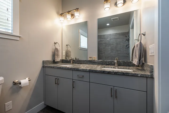 Bathroom featuring double vanity and a tile shower