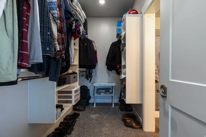 Walk in closet featuring dark colored carpet