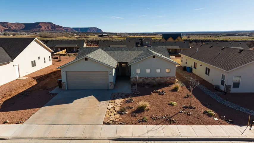 View of front of property featuring driveway, stucco siding, a residential view, and a mountain view