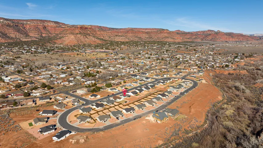 Aerial view of property and surrounding area with nearby suburban area and a mountain backdrop