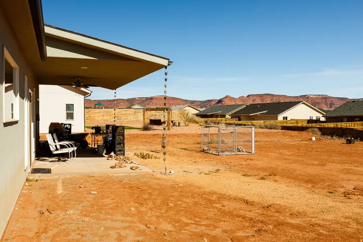 Fenced yard featuring a patio area, a mountain view, and a ceiling fan