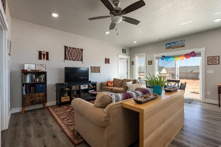 Living area featuring ceiling fan, a textured ceiling, dark wood finished floors, and recessed lighting