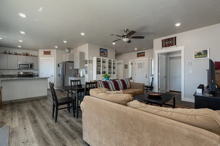 Living room with light wood-style flooring, ceiling fan, recessed lighting, and a textured ceiling