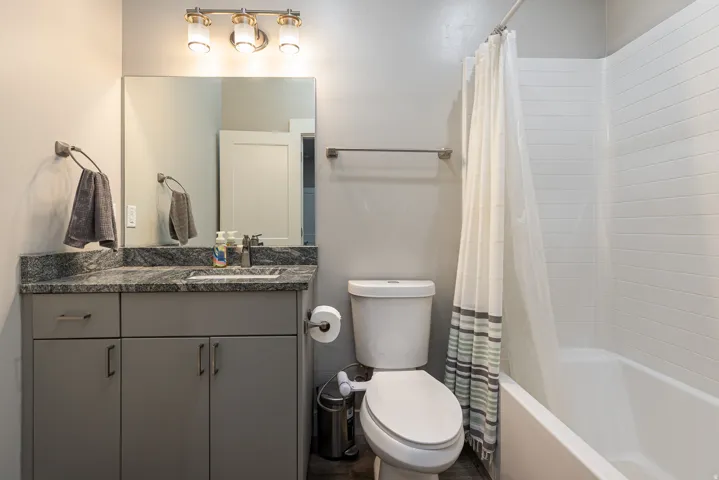 Bathroom featuring vanity and shower / bath combination with curtain