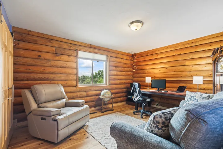 Office space featuring hardwood / wood-style flooring and log walls