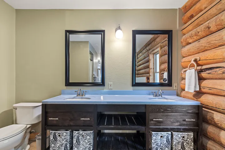 Full bath with double vanity and rustic walls