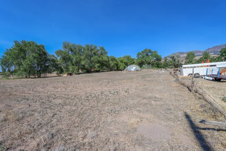 Expansive land parcel featuring mature trees, a geodesic dome structure, and a wooden fence line