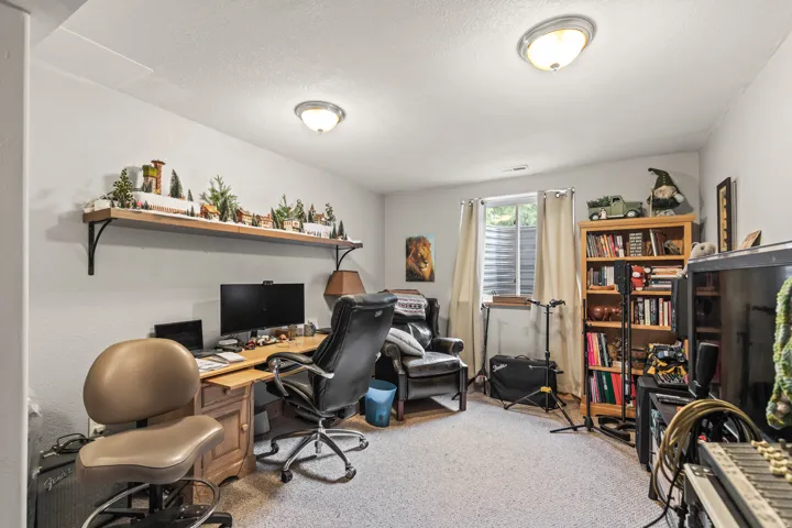 Office area featuring light carpet and a textured ceiling