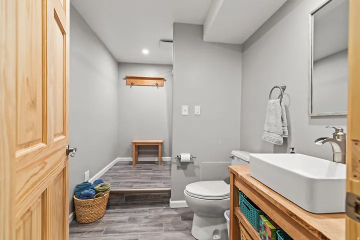 Half bath featuring wood tiled floors, vanity, and recessed lighting