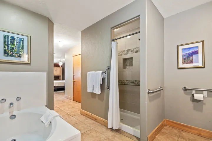 Full bathroom with connected bathroom, a bath, light tile patterned flooring, and a stall shower