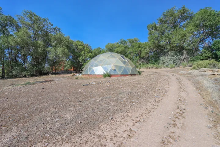 Geodesic dome structure with a clear panel exterior and a partial brick foundation