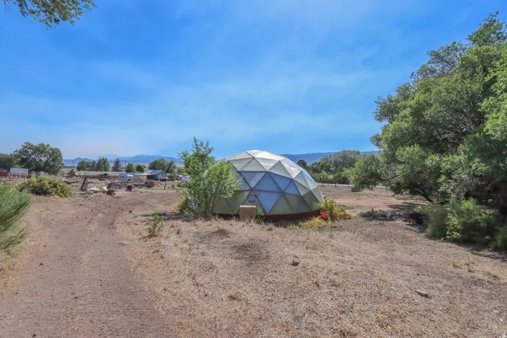 Geodesic dome structure on a spacious, unpaved lot