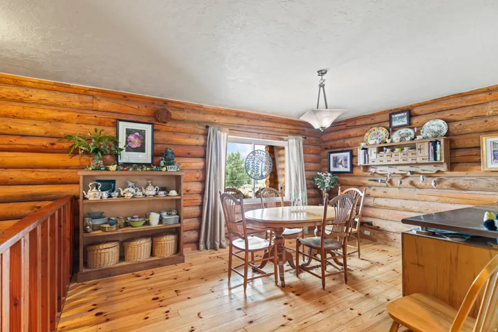 Dining space with a textured ceiling, light wood-style flooring, and rustic walls