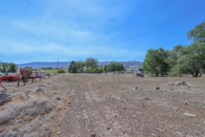 Expansive rural property featuring a wide, unpaved pathway