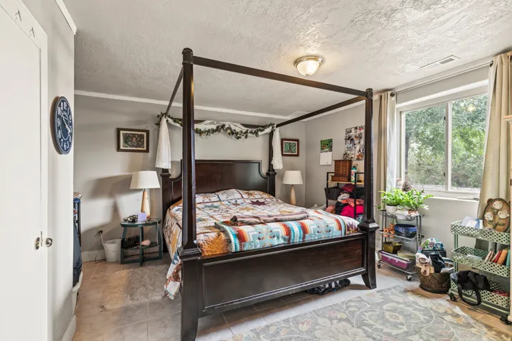 Bedroom with a textured ceiling and light tile patterned floors